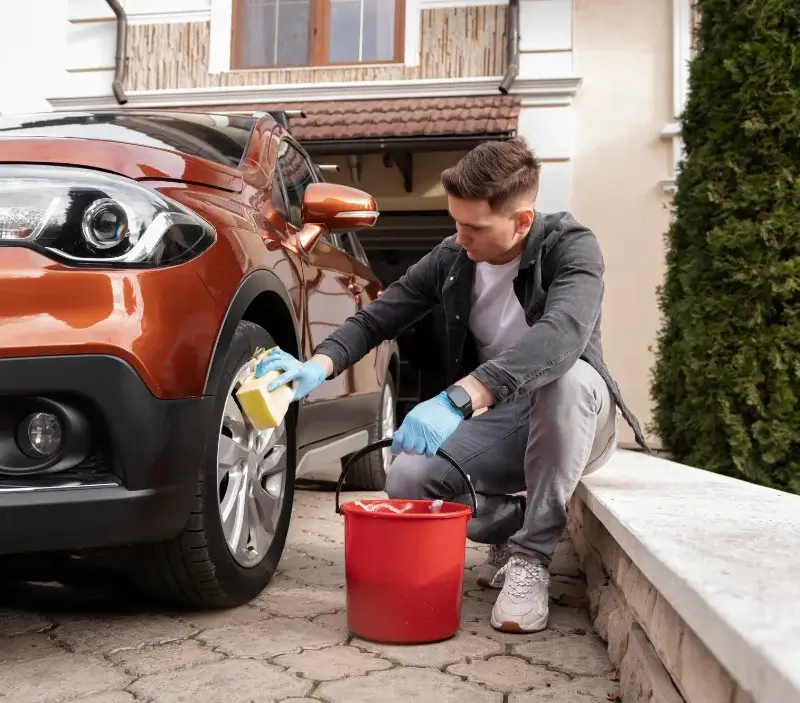 Lavage auto à domicile Valzin en Petite Montagne : professionnel intervenant sur un véhicule